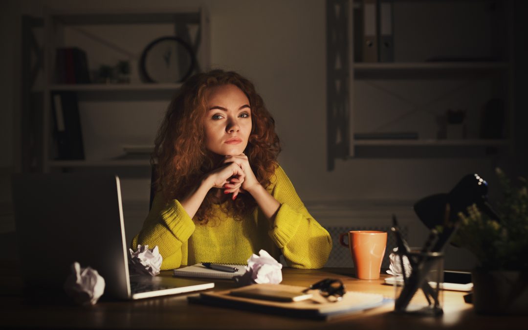 Tired serious business woman in office at night.