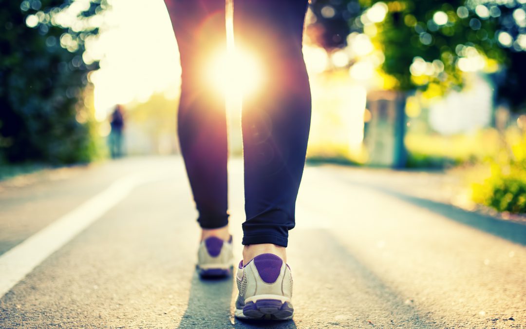 Close-up of woman athlete feet and shoes while running in park.