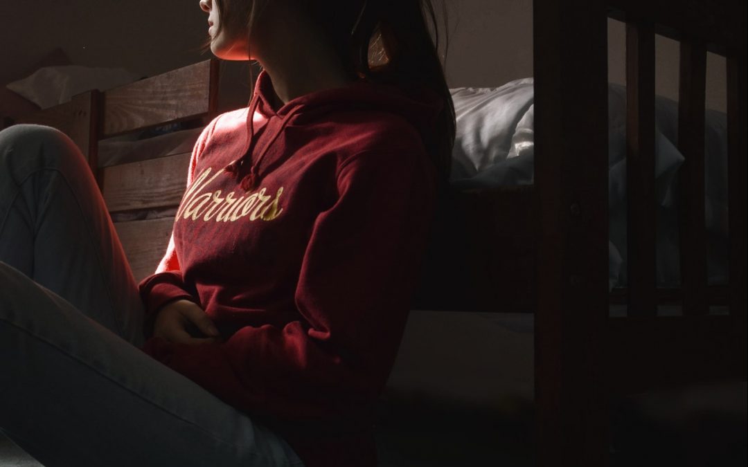 Young woman sitting on the floor in shadows