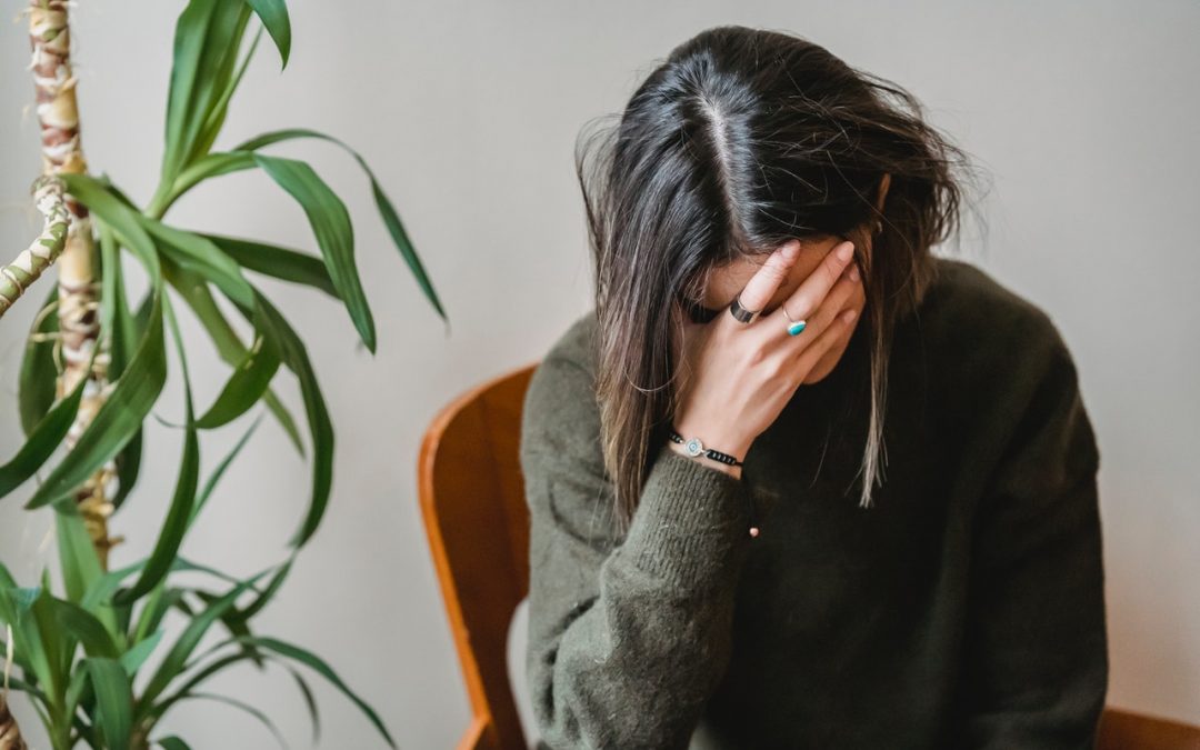 Stressed women with her head down in her hand.