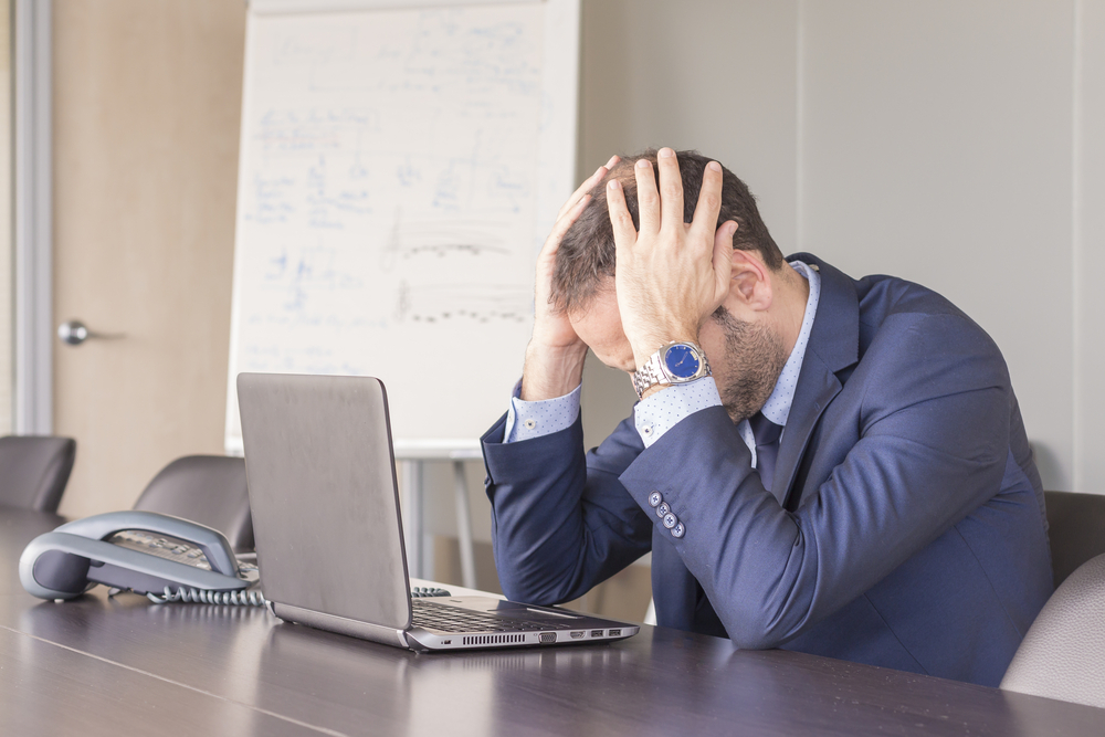 Frustrated businessman working on laptop